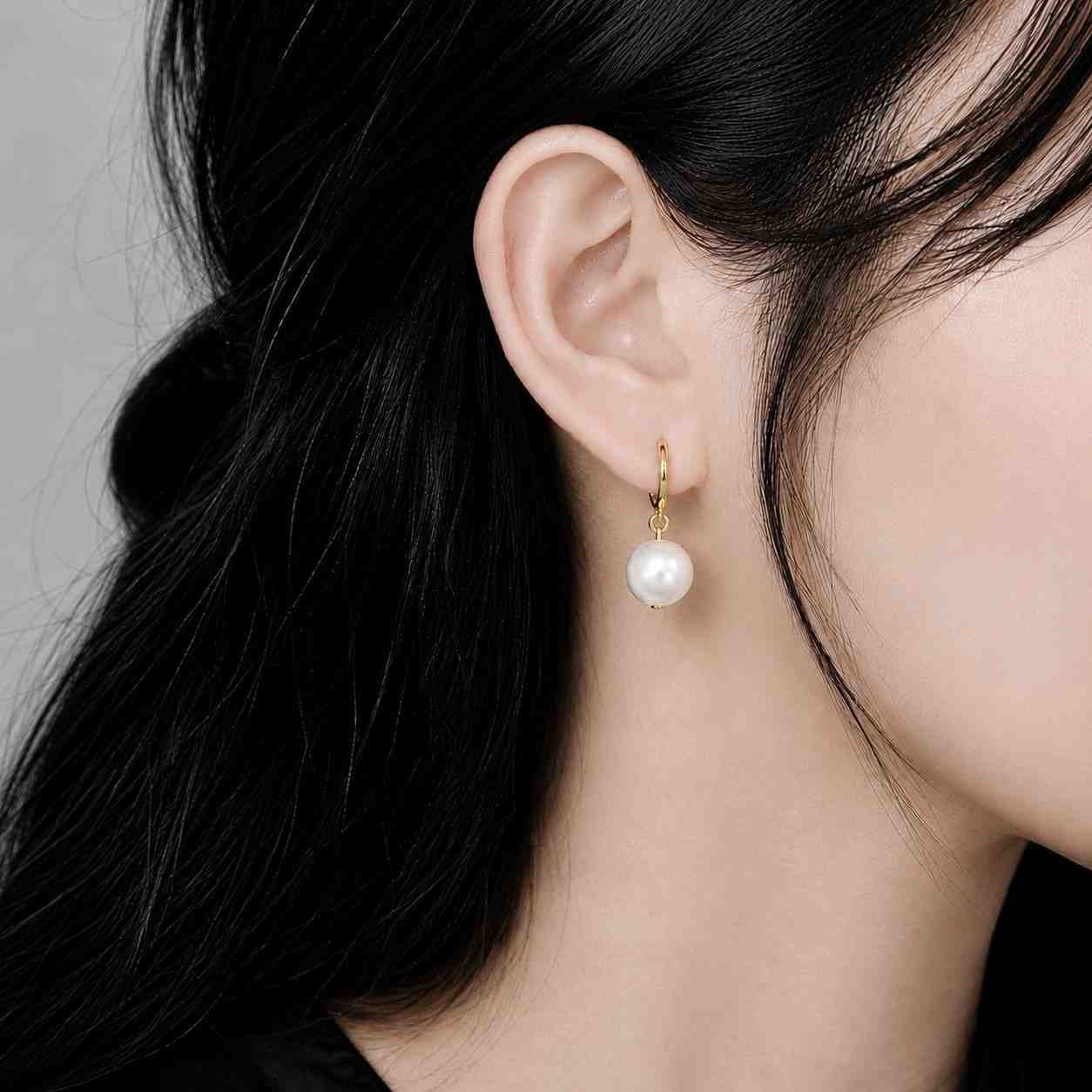 white pearl drop earrings worn on ear